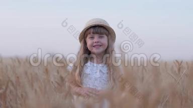 快乐的童年，美丽美丽的金发小女孩微笑着转过头站在金色的麦穗里